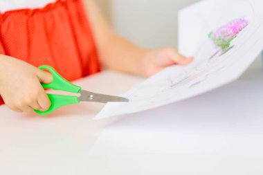 Çocuğun elinde makasla kağıt kesme