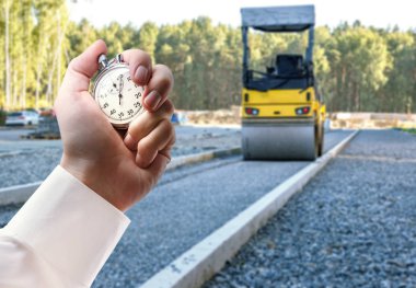 Yol silindiri çalışma ve elinde kronometre