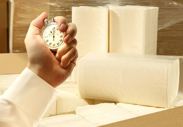 Paper napkins, towels and stopwatch in male hand