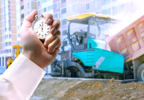 Asphalt-placing machine and stopwatch in hand — Stock Photo, Image