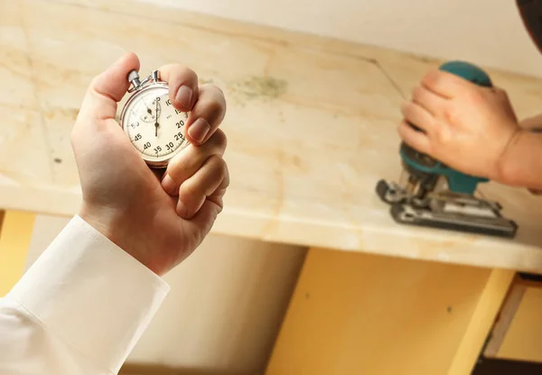 Installing works and stopwatch in hand — Stock Photo, Image