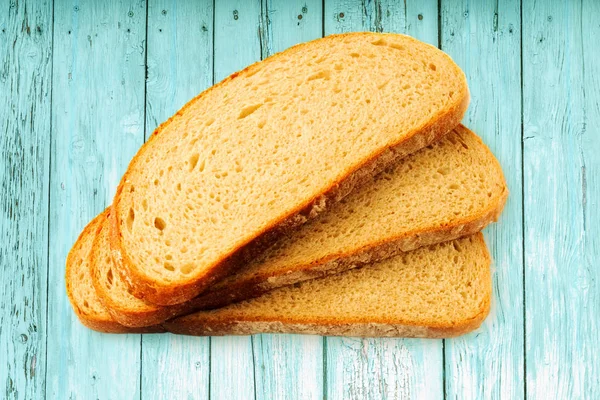 Slices of bread on wooden background — Stock Photo, Image