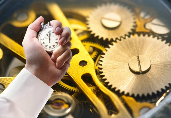 Clock inside mechanism and stopwatch in male hand — Stock Photo, Image