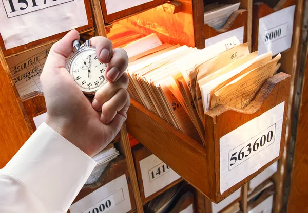 Papierdocumenten in archief en stopwatch in mannenhand — Stockfoto