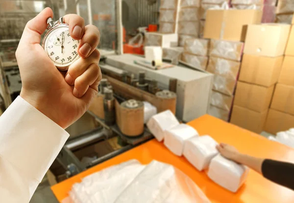 Processen av pappersprodukter tillverkning och tidtagarur i handen — Stockfoto