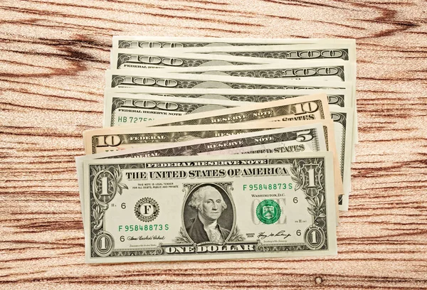 Billetes de dólar sobre fondo de madera —  Fotos de Stock