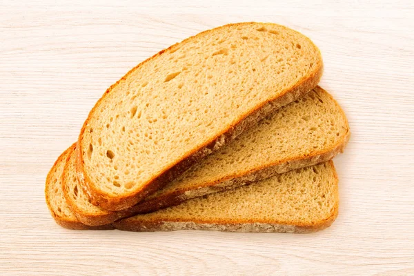 Fatias de pão no fundo de madeira — Fotografia de Stock