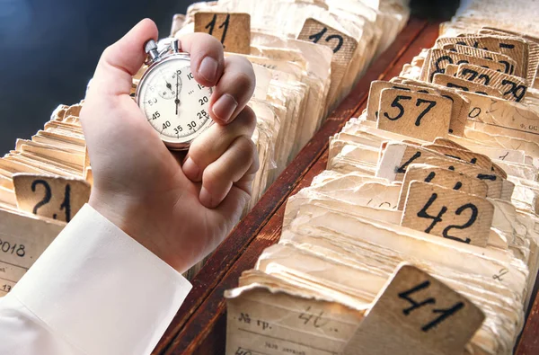 Archive file folders and stopwatch in male hand — Stock Photo, Image