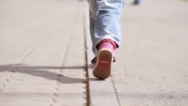 Liten flicka som går på trottoaren — Stockvideo