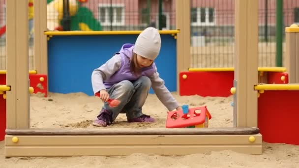 Маленькая девочка играет на детской площадке — стоковое видео