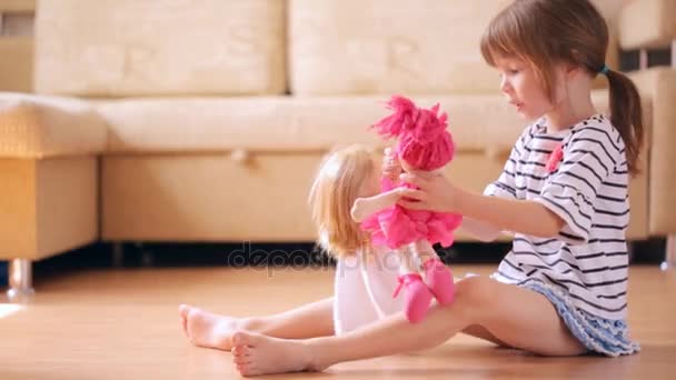 Niña jugando con muñecas — Vídeo de stock