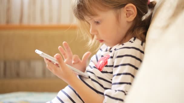 Kleines Mädchen spielt mit dem Smartphone — Stockvideo