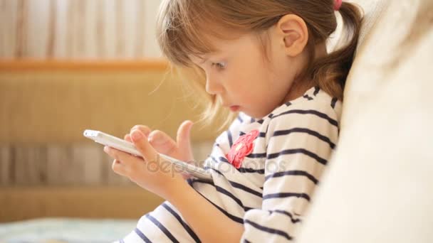 Little girl playing with the smartphone — Stock Video