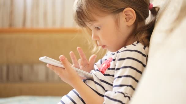 Kleines Mädchen spielt mit dem Smartphone — Stockvideo