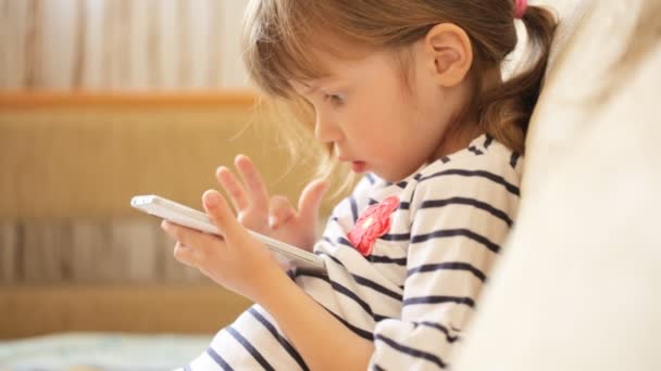 Kleines Mädchen spielt mit dem Smartphone — Stockvideo