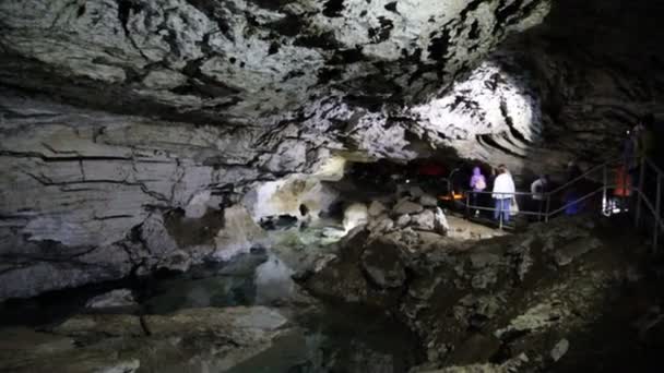 Pessoas caminhando pela caverna — Vídeo de Stock