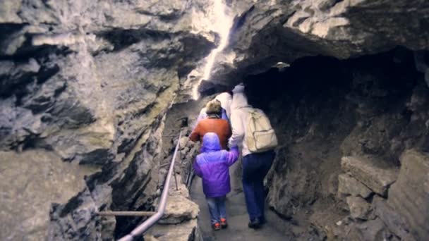 Menschen gehen durch die Höhle — Stockvideo