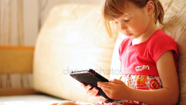 Gadis kecil memegang e-book di tangannya — Stok Video