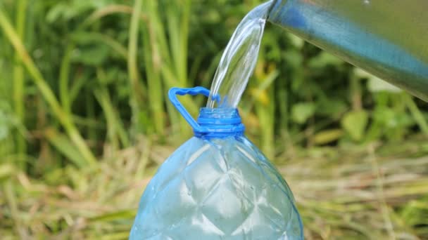 Verter agua limpia en la botella de plástico — Vídeo de stock