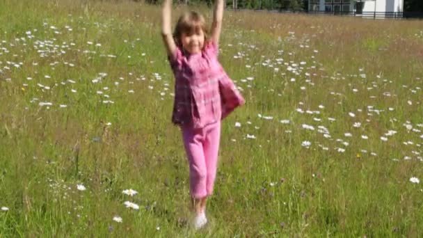 Enfant sautant sur le champ de camomille le matin d'été — Video