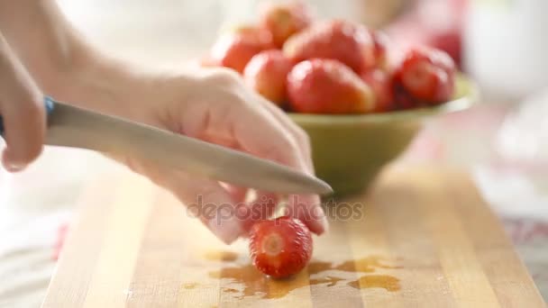 Frauenhände schneiden frische Erdbeeren — Stockvideo