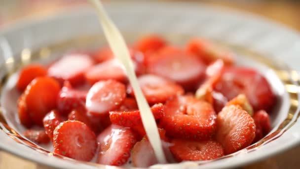 Frische Milch in Schüssel voller Erdbeeren gießen — Stockvideo