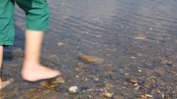 Vuxen och barnets fötter i vatten — Stockvideo