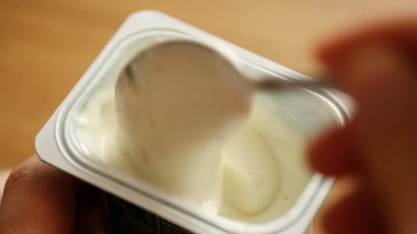 Еда йогурта из пластиковой чашки — стоковое видео