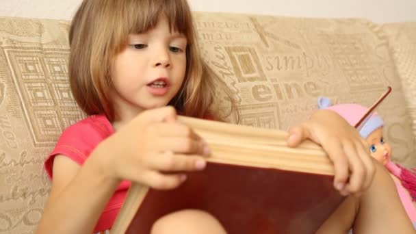 Niña leyendo un libro grande — Vídeo de stock