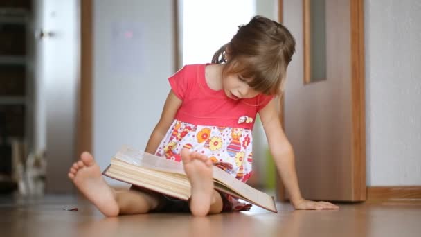 大きな本を読む小さな女の子 — ストック動画