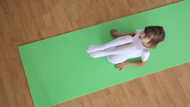 Liten flicka utövar på golvmatta — Stockvideo