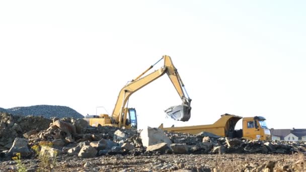 Graafmachine en vrachtwagen werken op de bouwplaats — Stockvideo