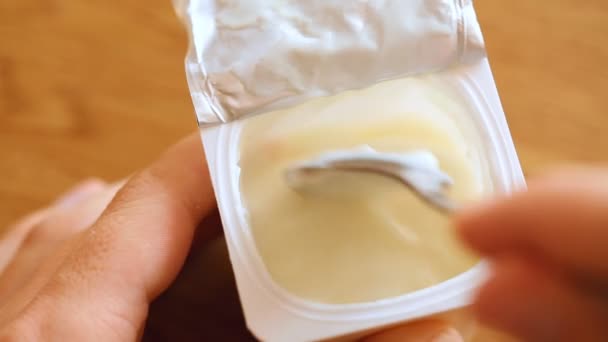 Att äta yoghurt från en plastmugg — Stockvideo