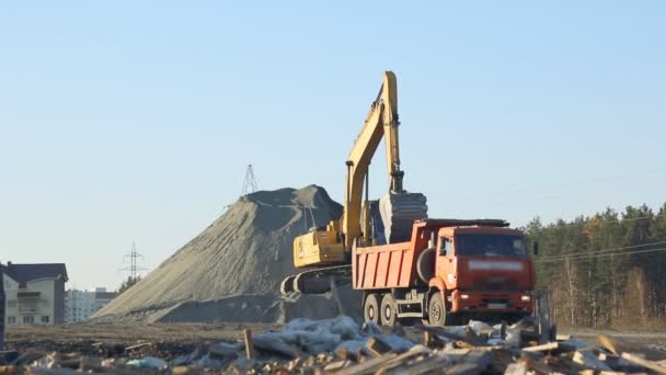 Escavadeira e camiões que trabalham no estaleiro — Vídeo de Stock