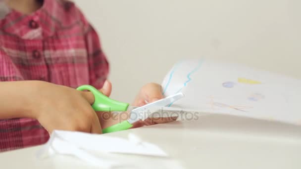 Manos de niño cortando papel con tijeras — Vídeo de stock