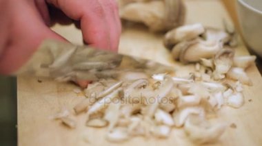 Erkek doğrama mantar yemek pişirmek için eller