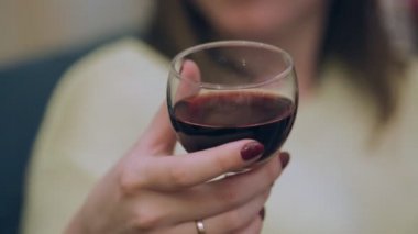 Genç kadın şarap bardaktan bir yudum alarak