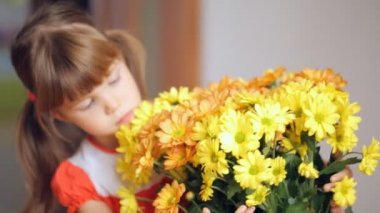 Küçük kız sarı çiçek demet kucaklayan