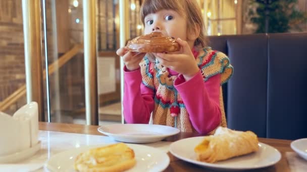 Kleines Mädchen Isst Ein Süßes Brötchen — Stockvideo