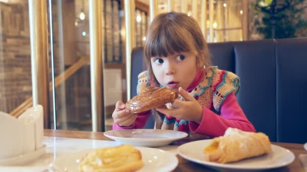 Kleines Mädchen Isst Ein Süßes Brötchen — Stockvideo