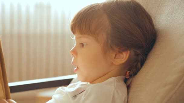 Menina Pequena Lendo Livro Poltrona — Vídeo de Stock