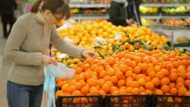 Kadın süpermarkette meyve seçimi