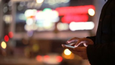 Smartphone içinde erkek gece şehir arka plan üzerinde eller