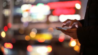Smartphone içinde erkek gece şehir arka plan üzerinde eller