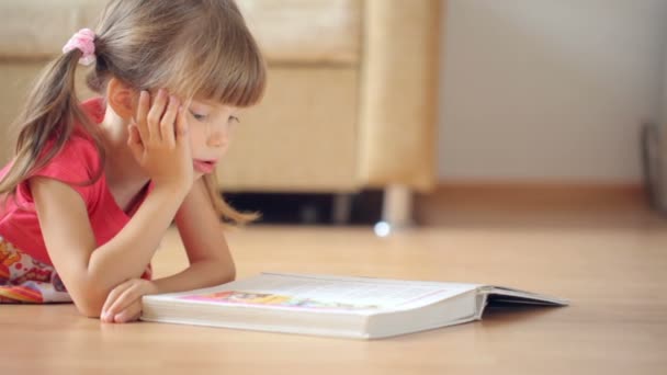 Μικρό Κορίτσι Διαβάζει Βιβλίο Στο Πάτωμα — Αρχείο Βίντεο