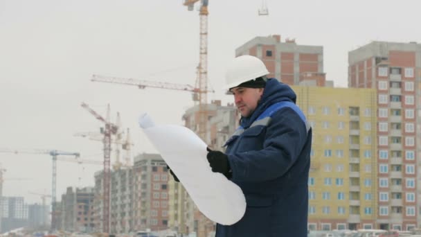 Förman Med Papper Ritning Plan Vid Byggprojekt — Stockvideo