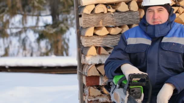 Arbeiter Mit Kettensäge Gegen Holzstapel — Stockvideo