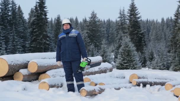 Arbetare Med Motorsåg Nära Högen Stockar Skogen — Stockvideo