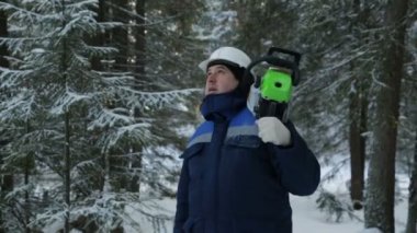 İşçi kış ormanda etrafa omuz chainsaw ile