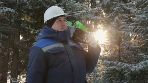 Pracownik Piłą Ramieniu Rozglądając Się Zimowym Lesie — Wideo stockowe